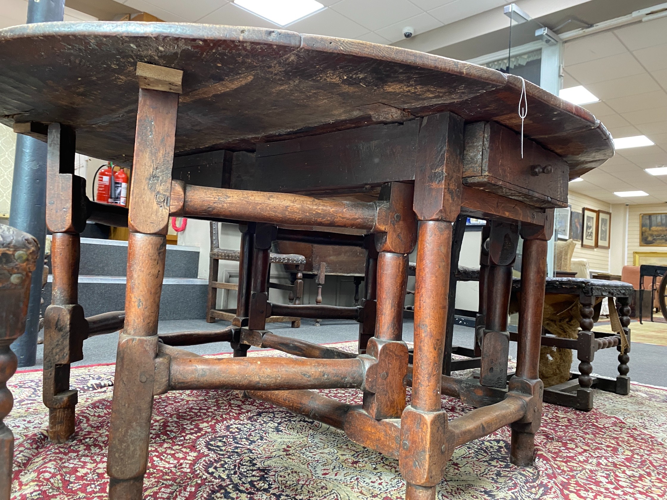 A 17th century oak gateleg table, length 168cm extended, width 150cm, height 76cm